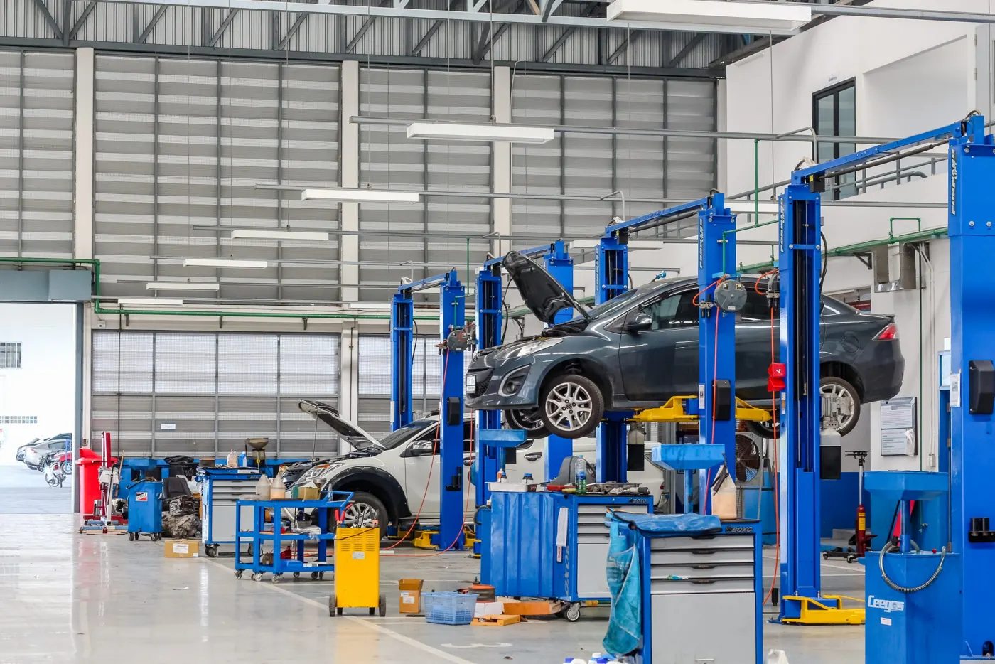 A blue two-post car lift in a workshop